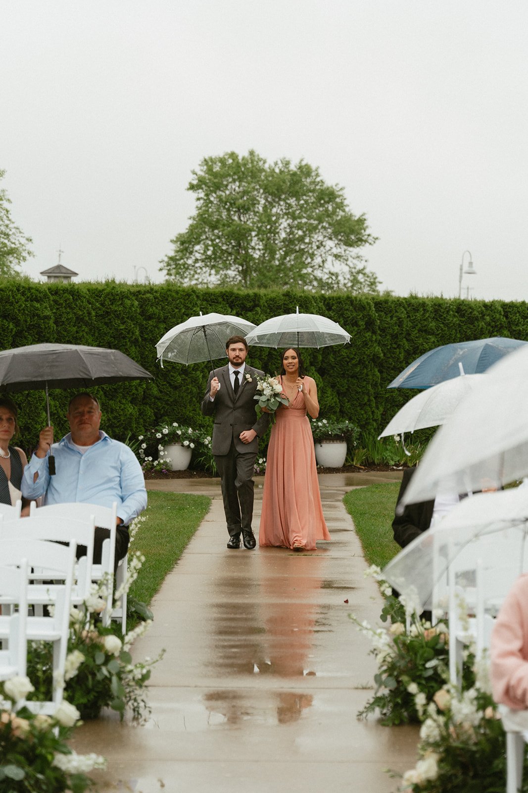 Bridesmaid walking with an umbrella in the rain