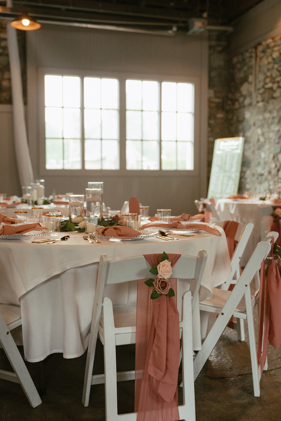 Empty reception tablescape set with pink linens and florals