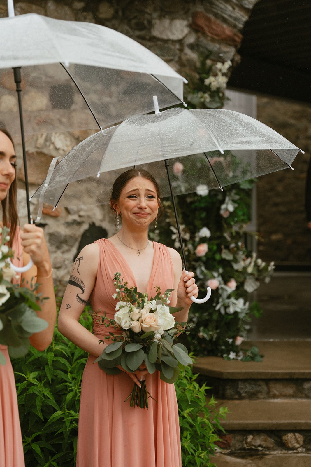 Bride walking away in the rain with a clear umbrella